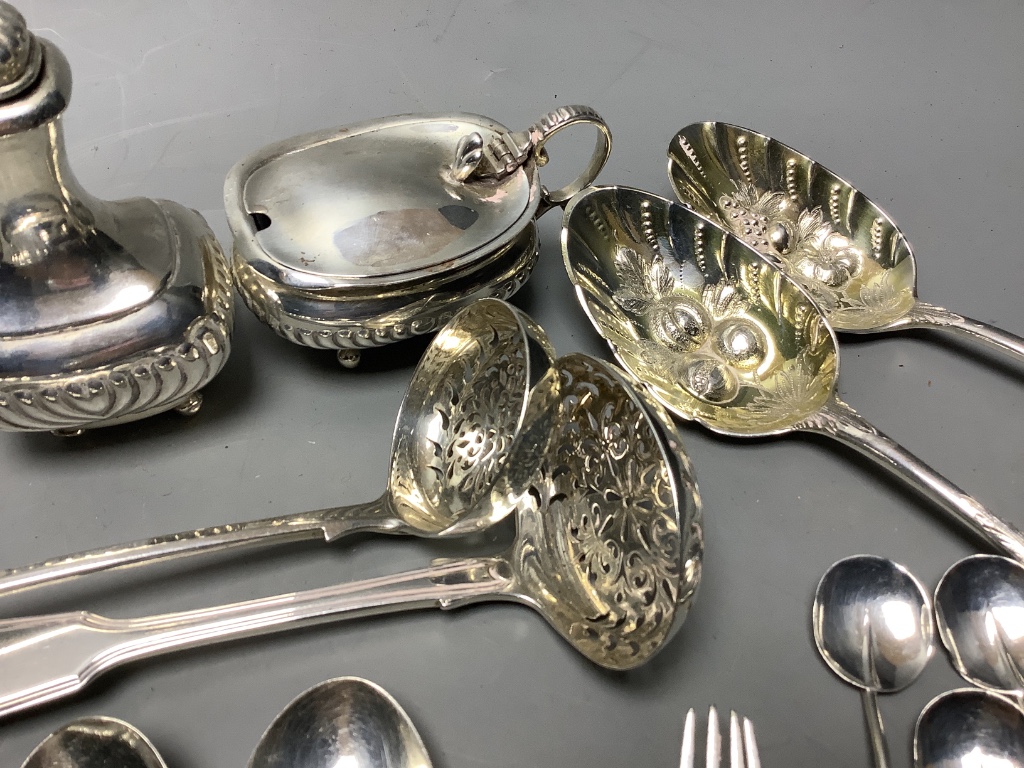 A three-piece silver condiment of oval half-reeded form, two silver sifter spoons, a pair of silver berry spoons and sundry silver flatware, approximately 18oz